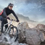 Radfahrer downhill über Felsen und Wasser