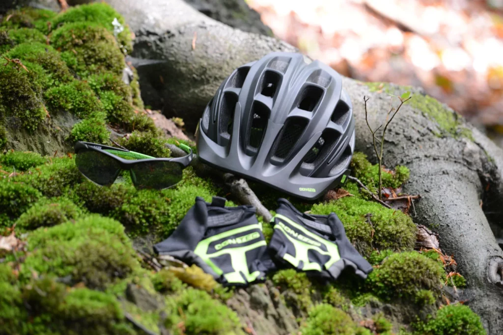 Fahrradhelm, -brille, -handschuhe auf Moos